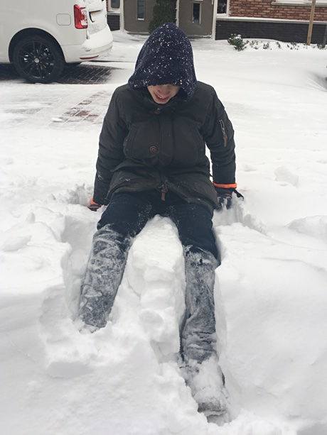 Adam sitting in a pile of snow