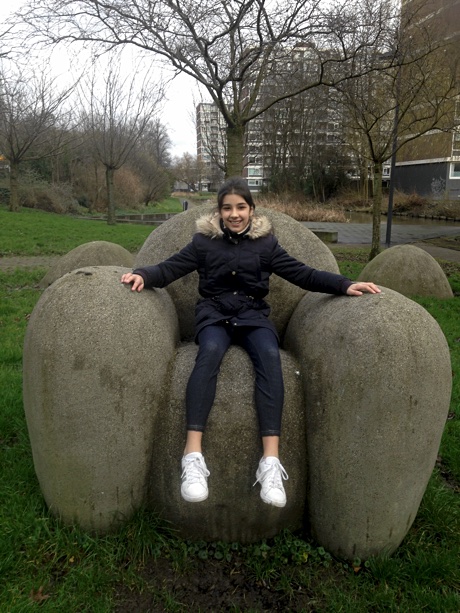 Alice sitting in a stone chair